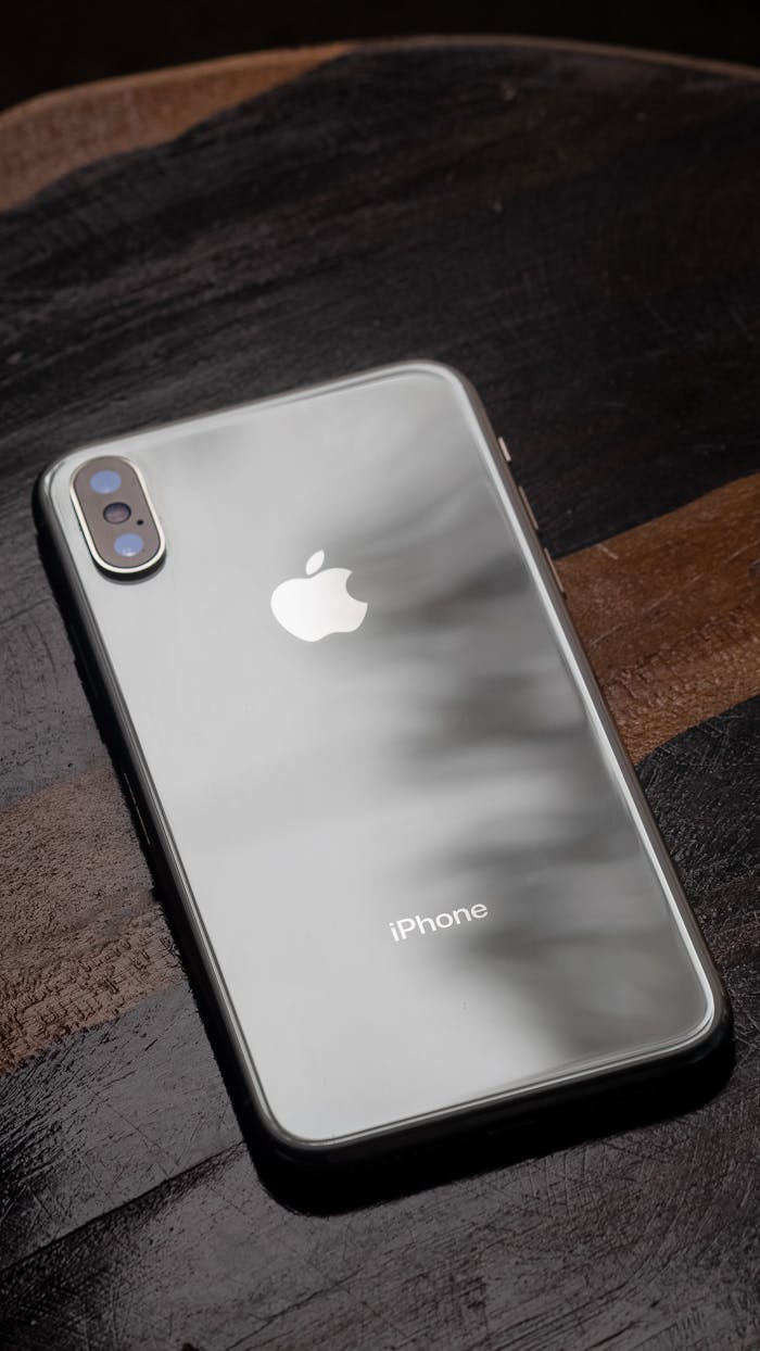 Elegant iPhone displayed on a dark wooden table showcasing its sleek design.